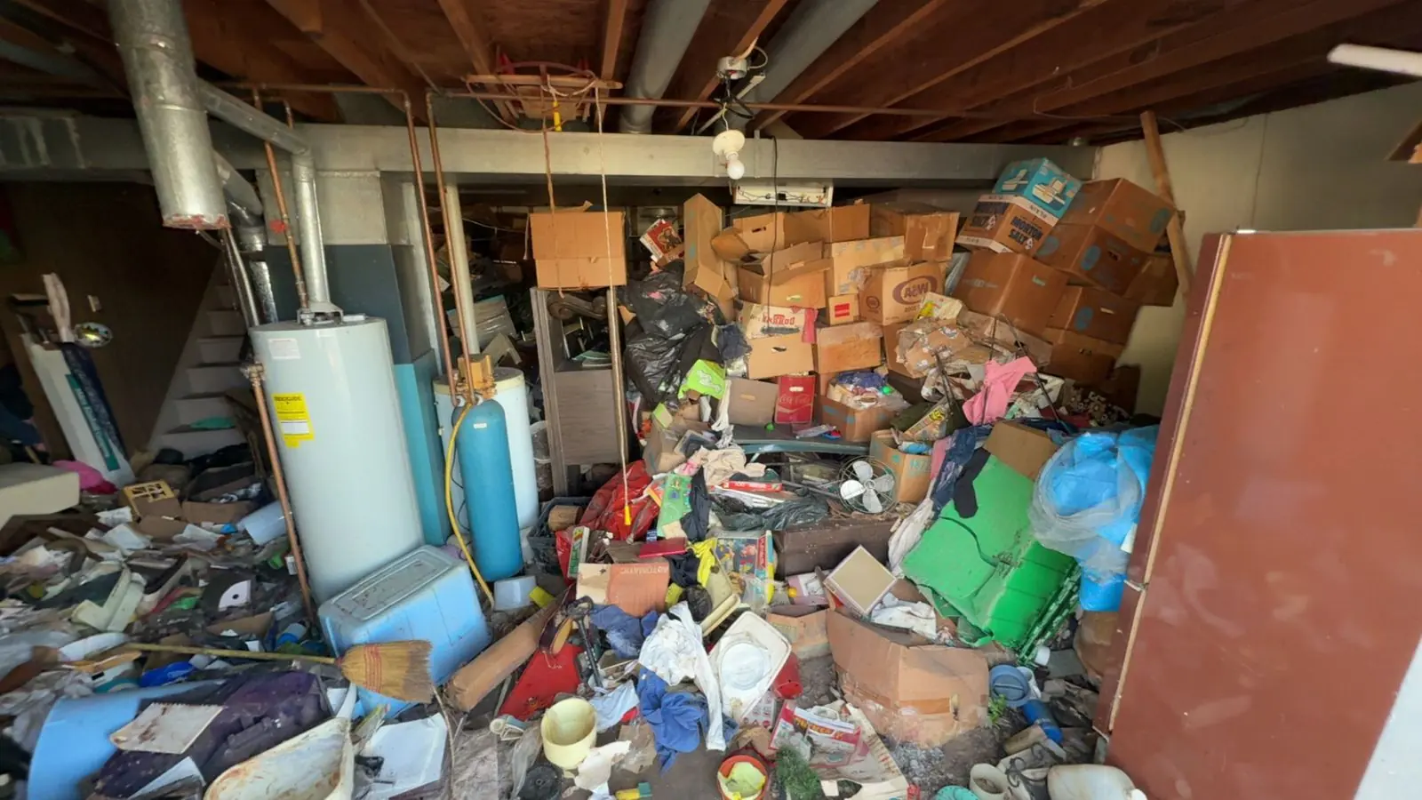 Basement full of junk before a No Mo Junk cleanout
